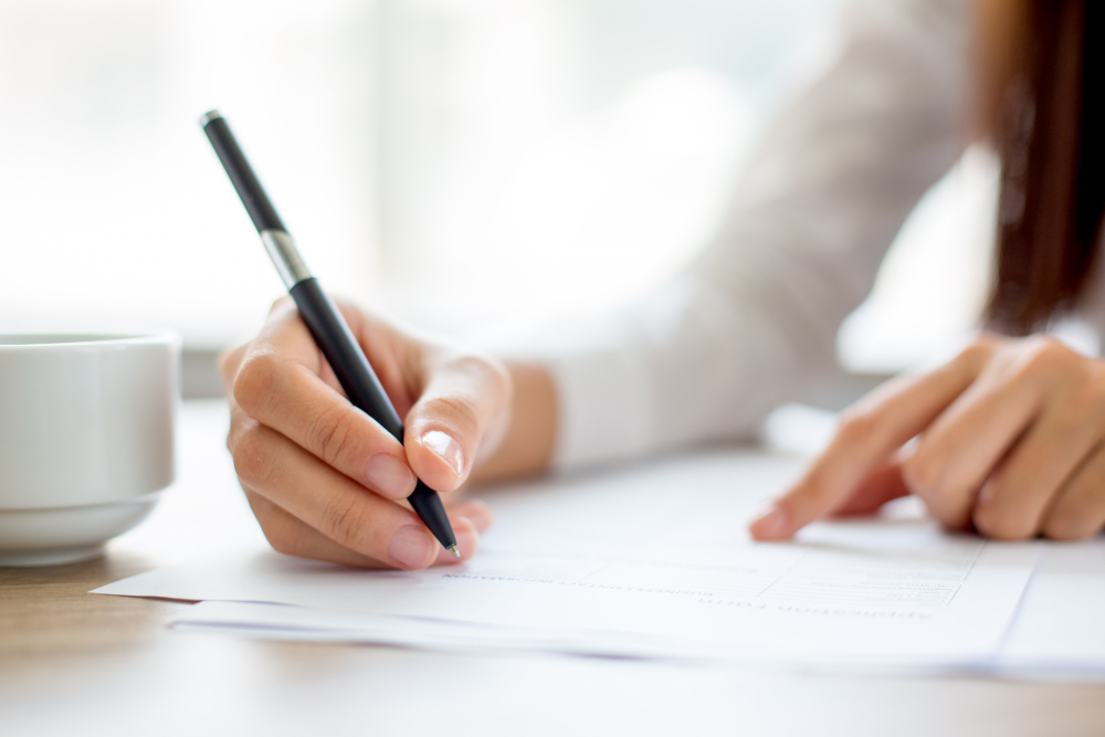 /upl/hand-of-businesswoman-writing-on-paper-in-office.jpg