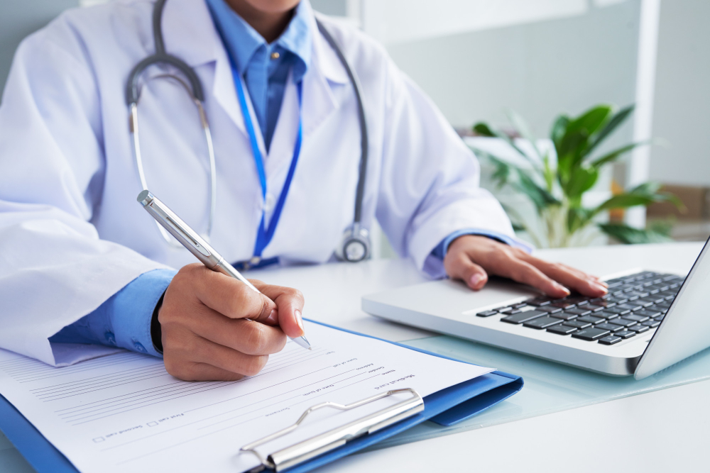 /upl/hands-of-unrecognizable-female-doctor-writing-on-form-and-typing-on-laptop-keyboard.jpg